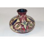 A squat ovoid shape vase, Moorcroft, with a tubelined design of flowers on a pink ground