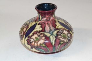 A squat ovoid shape vase, Moorcroft, with a tubelined design of flowers on a pink ground