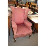 A Georgian style wing back armchair, for reupholstery