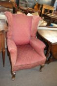 A Georgian style wing back armchair, for reupholstery