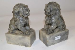 A pair of Oriental soapstone lions on rectangular bases, 15cm high