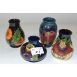 A group of four small baluster shape Moorcroft vases, one with an orchid design on blue ground, a