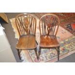 Two Victorian stick back kitchen chairs with elm seats and turned legs, one with a pierced back