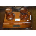 Small two bottle desk stand with brass plaque marked "This is made of timber which was used in the