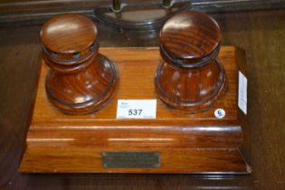 Small two bottle desk stand with brass plaque marked "This is made of timber which was used in the