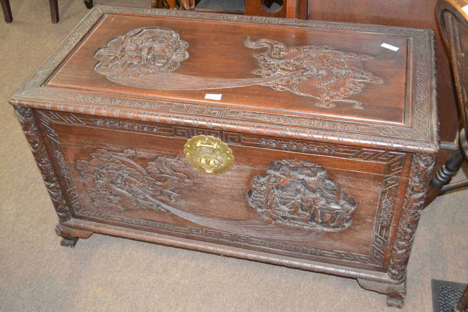 A 20th Century Chinese camphor wood blanket box of hinged rectangular form decorated with carved