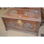 A 20th Century Chinese camphor wood blanket box of hinged rectangular form decorated with carved