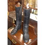 A pair of vintage black leather riding boots with stretchers