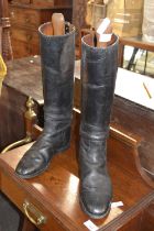 A pair of vintage black leather riding boots with stretchers