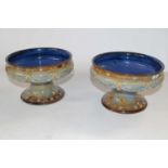 A pair of Royal Doulton tazzae, both with applied floral design of swags, 19cm diameters