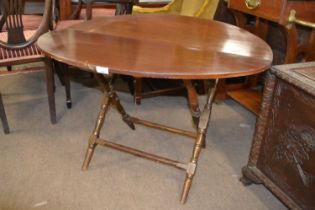 A late 19th Century mahogany coaching table of folding circular form raised on turned legs,