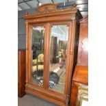 Late 19th Century continental walnut wardrobe with arched pediment, two doors with bevelled mirrored