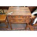 A Georgian walnut veneered two drawer side table or low boy with pierced handles and square legs,