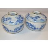 Two Oriental porcelain bowls and covers with blue and white designs, the covers with good luck