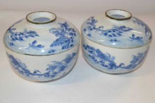 Two Oriental porcelain bowls and covers with blue and white designs, the covers with good luck