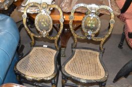 A pair of Victorian mother of pearl, ebonised and papier mache finished cane seated chairs decorated