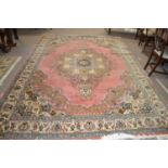 A 20th Century Turkish style wool rug decorated with a large central panel on a principally blue and