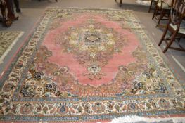 A 20th Century Turkish style wool rug decorated with a large central panel on a principally blue and