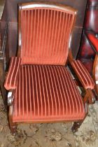A Victorian rosewood framed and striped upholstered armchair with turned legs and casters