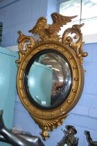 A reproduction Georgian style gilt wood porthole mirror with eagle mount, approx 100cm high (a/f)
