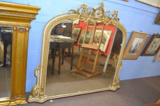 A large Victorian over mantel mirror of arched form set in a gilt and cream painted frame, 165cm