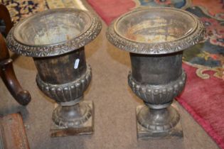 A pair of reproduction small cast iron garden urns, 30cm high