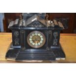 A large Victorian black slate mantel clock set in an architectural type case