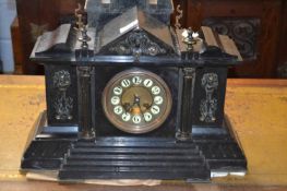 A large Victorian black slate mantel clock set in an architectural type case