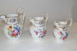 Three 19th Century Swansea style jugs decorated in relief with flower heads and painted floral