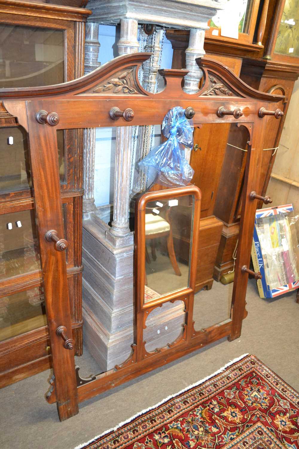 A late Victorian American walnut coat rack with central mirror and arched pediment, 127 x 146 cm