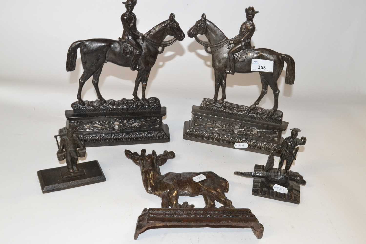 A pair of cast iron door stops formed as figures on horseback together with a further iron
