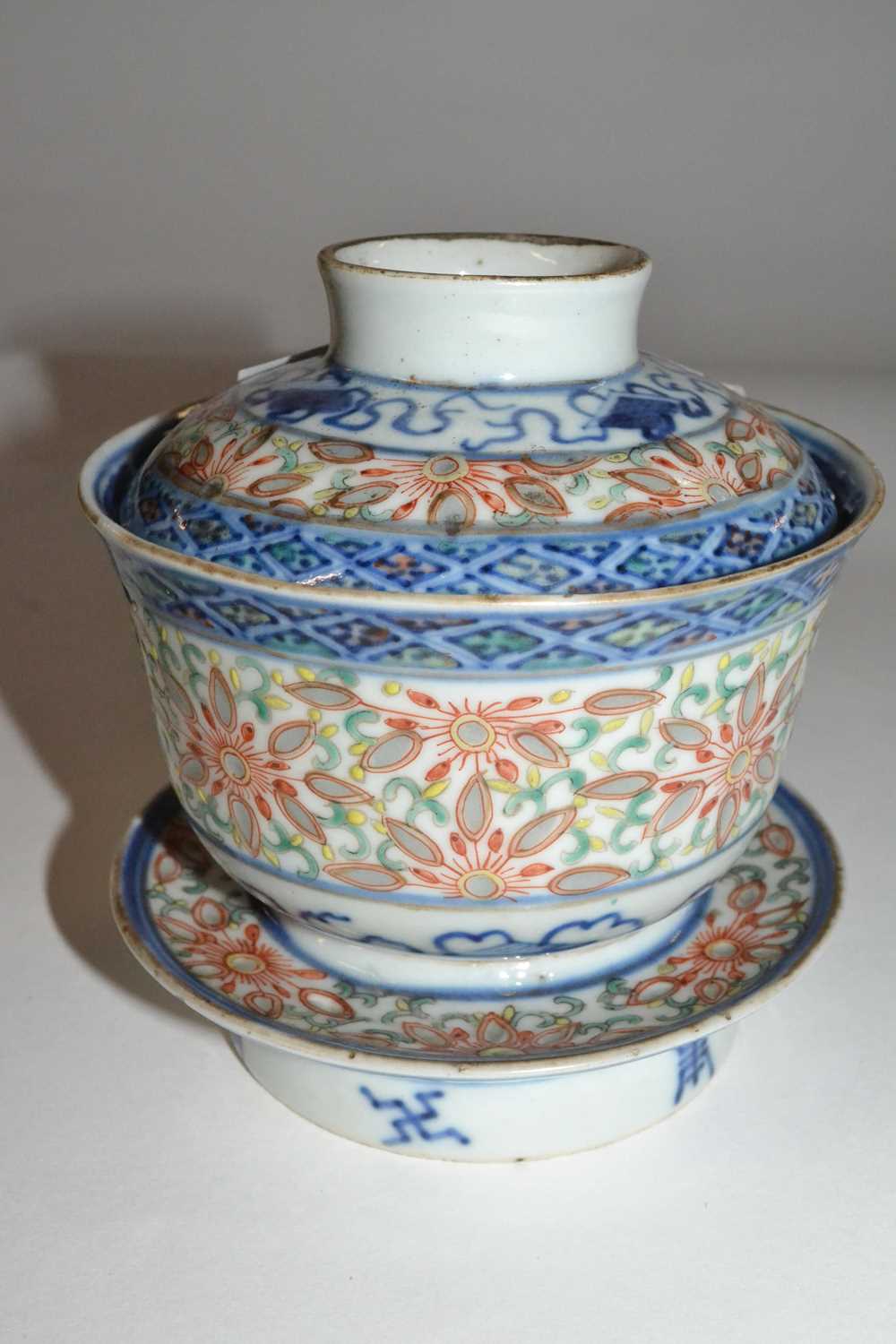 A Chinese porcelain rice bowl, cover and stand with rice grain polychrome design, the base with