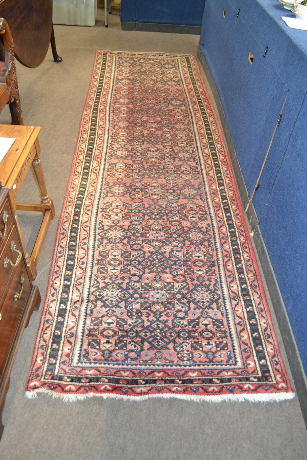 A Caucasian wool runner carpet with close geometric design in faded red, blue and black, approx