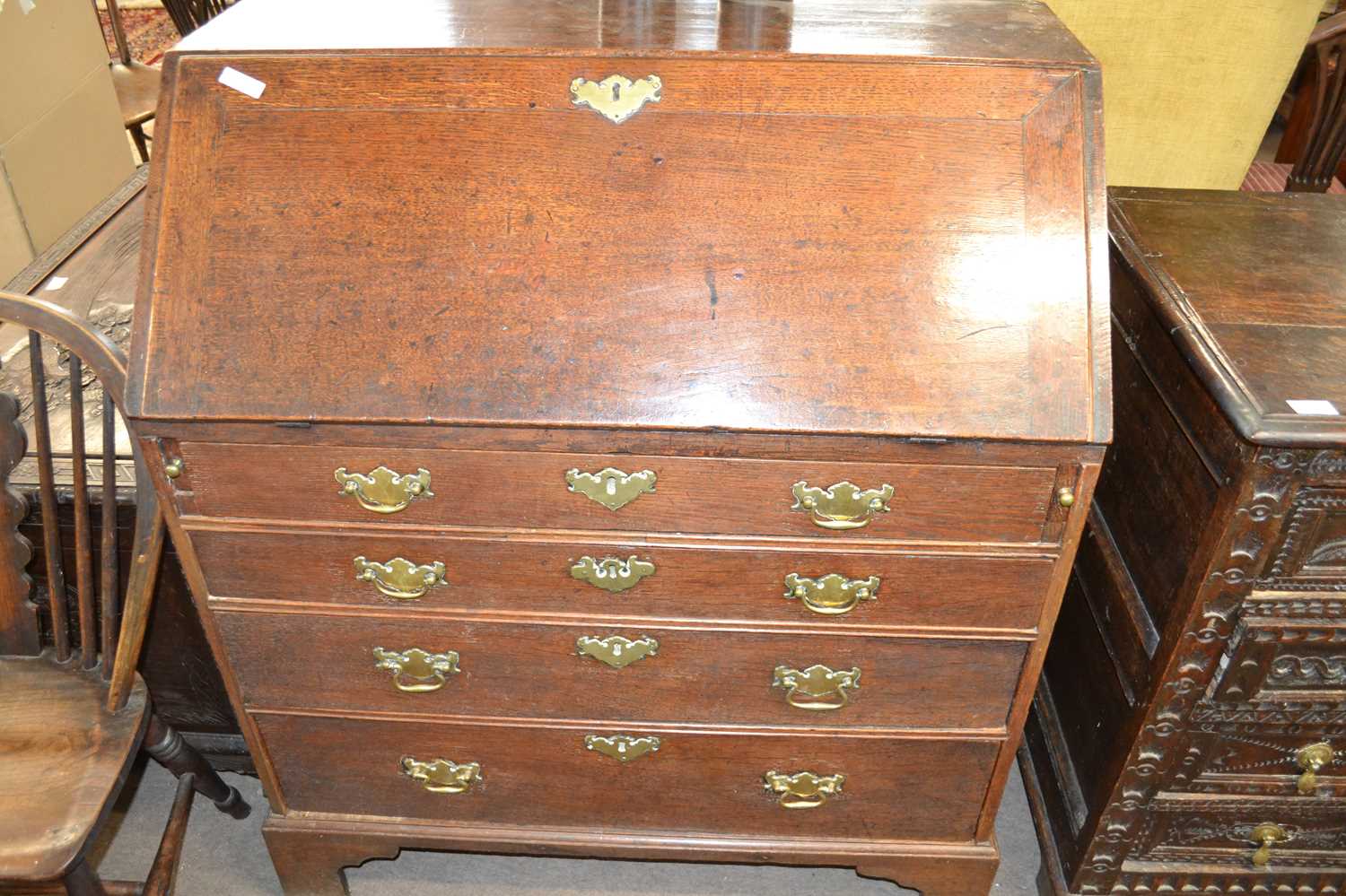 A George III oak bureau of typical form with full front opening to a fitted interior, over a four - Image 2 of 3