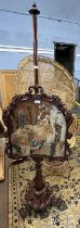 A Victorian mahogany framed pole screen, the panel decorated with a needlework classical scene,