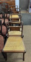 A set of four Regency mahogany framed and cane seated sabre leg dining chairs