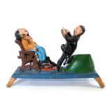 Vintage cast iron money box Costano the dentist and his patient, coin slot into his side nd then