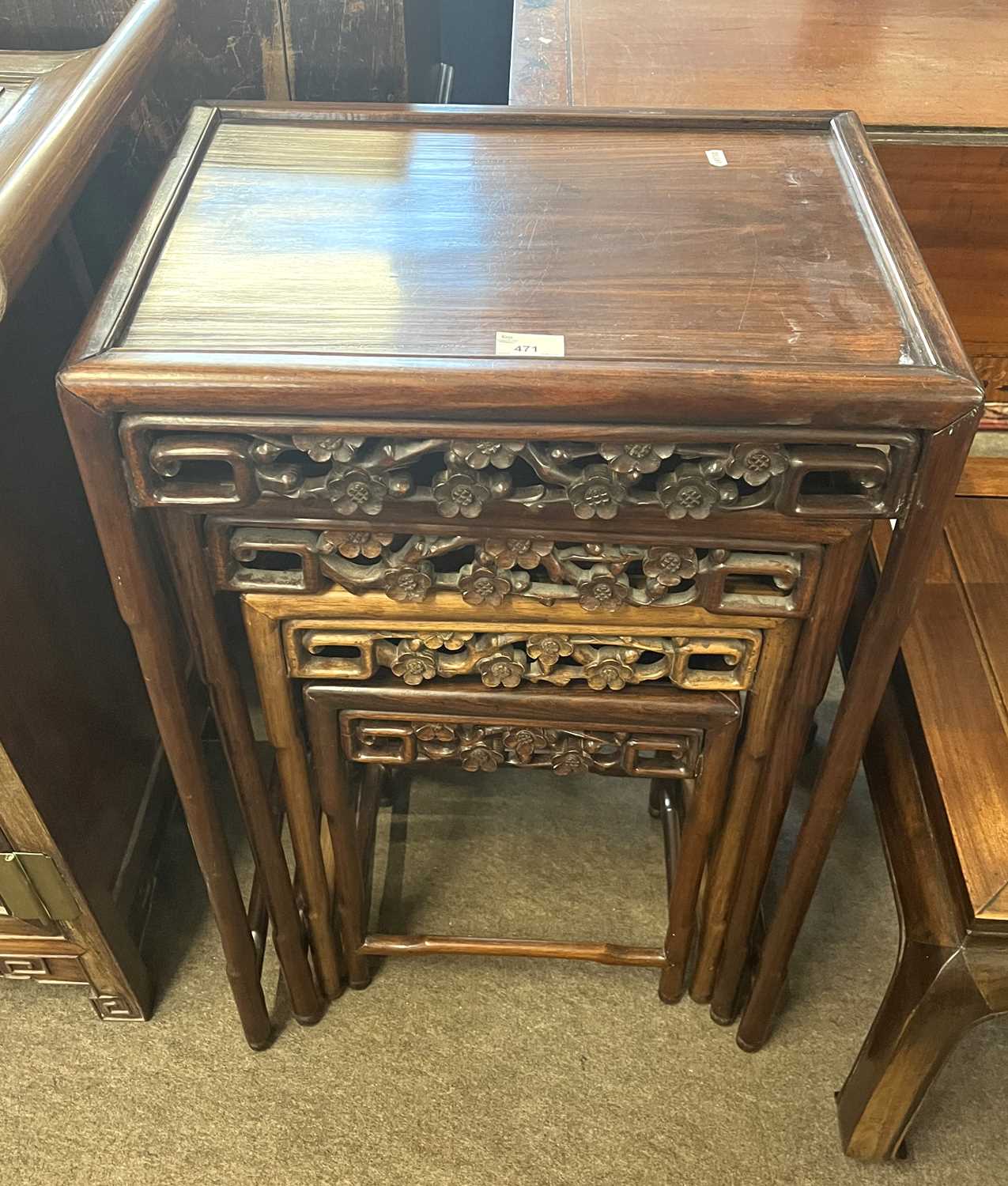 A nest of four Chinese hardwood tables with pierced floral decoration, largest 50cm wide