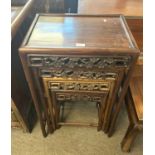 A nest of four Chinese hardwood tables with pierced floral decoration, largest 50cm wide