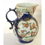 An 18th Century Worcester mask jug with blue ground with panels of Kakiemon style decoration (broken