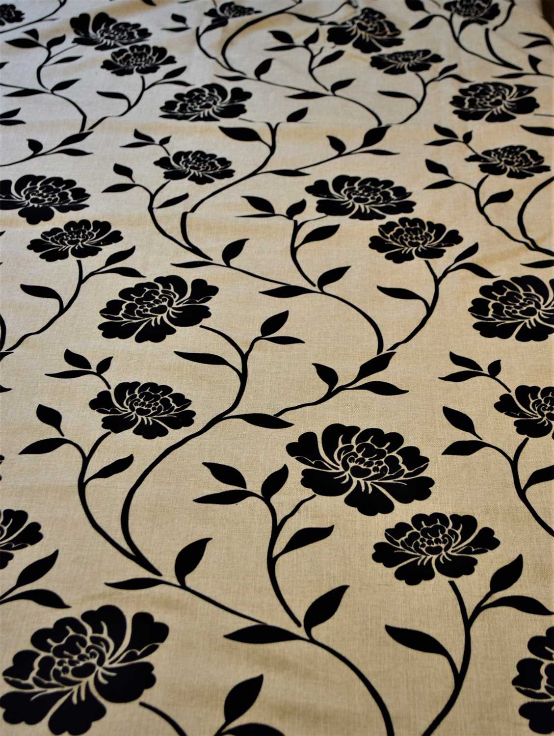 A pair of beige and black floral velour patterned curtains, lined, each approx. 152cm wide by