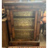 A Victorian walnut veneered pier cabinet of typical form with single glazed door and platform