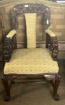 A 20th Century Chinese hardwood armchair carved with intricate dragon detail and front cabriole legs