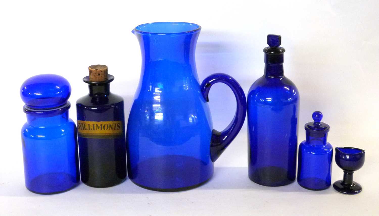 Group of Bristol blue glass wares including a large jug, eye bath and a chemists bottle