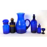 Group of Bristol blue glass wares including a large jug, eye bath and a chemists bottle
