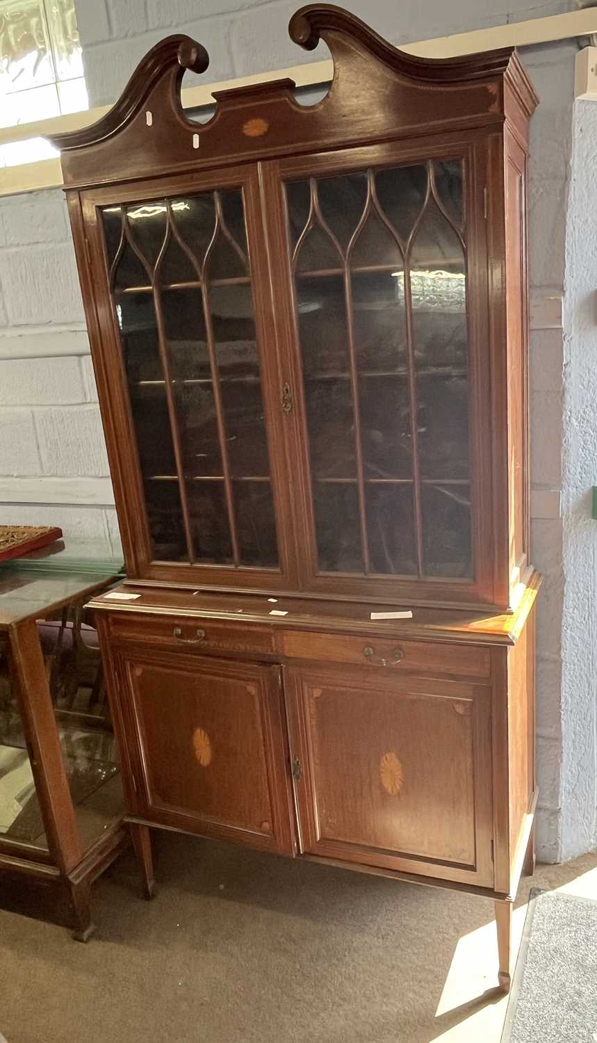 An Edwardian mahogany side cabinet with broken arch pediment over two astragal glazed doors and a