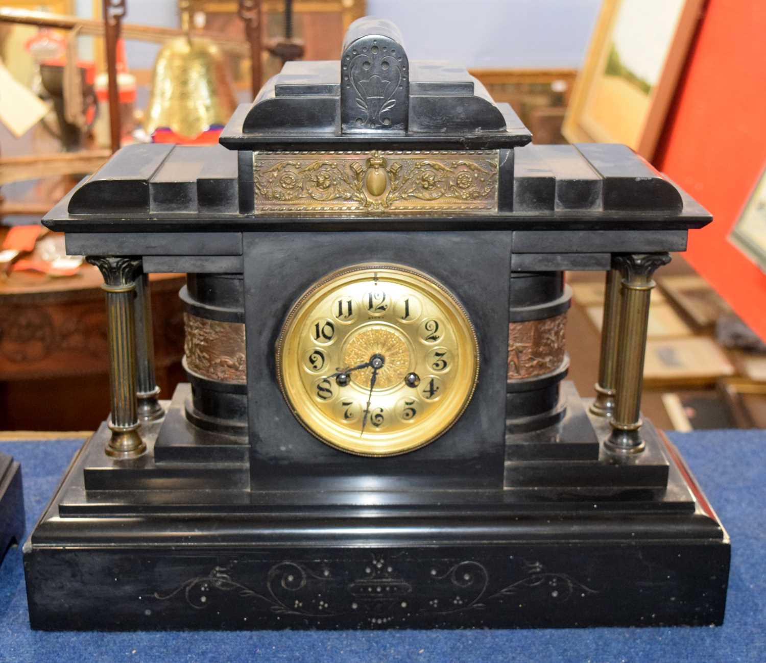 A large Victorian black slate clock, the gilt face with black numerals with four small Corinthian