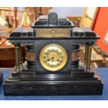 A large Victorian black slate clock, the gilt face with black numerals with four small Corinthian