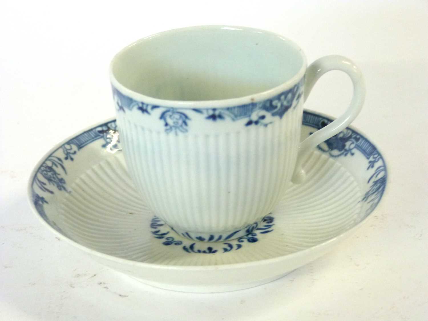 A Worcester porcelain cup and saucer, the ribbed body with a blue and white design to border