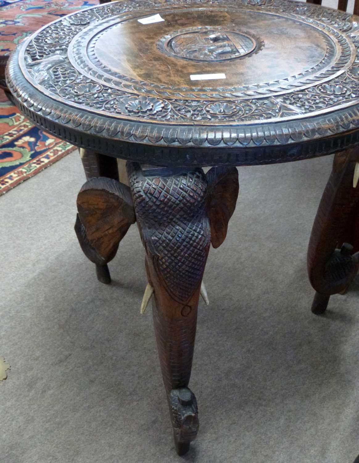 An Indian hardwood occasional table with circular carved top supported on elephant shaped legs, - Image 3 of 3